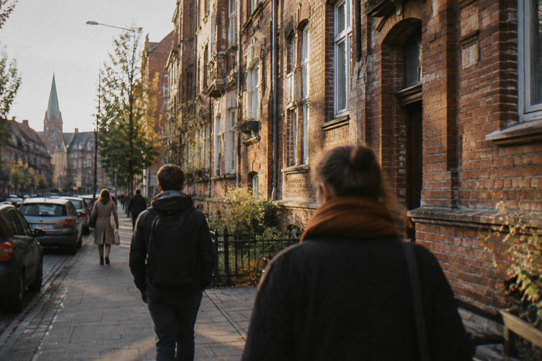 Visitors walking beside the brick tenement facades of the Nadodrze district in Wroclaw