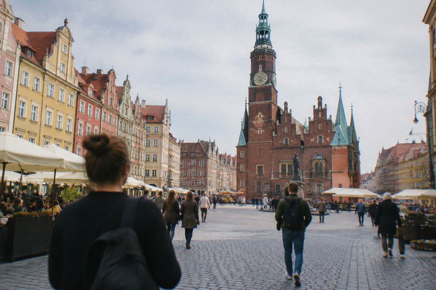 Sunlit medieval market square in Wroclaw with colorful townhouses and the Gothic town hall tower