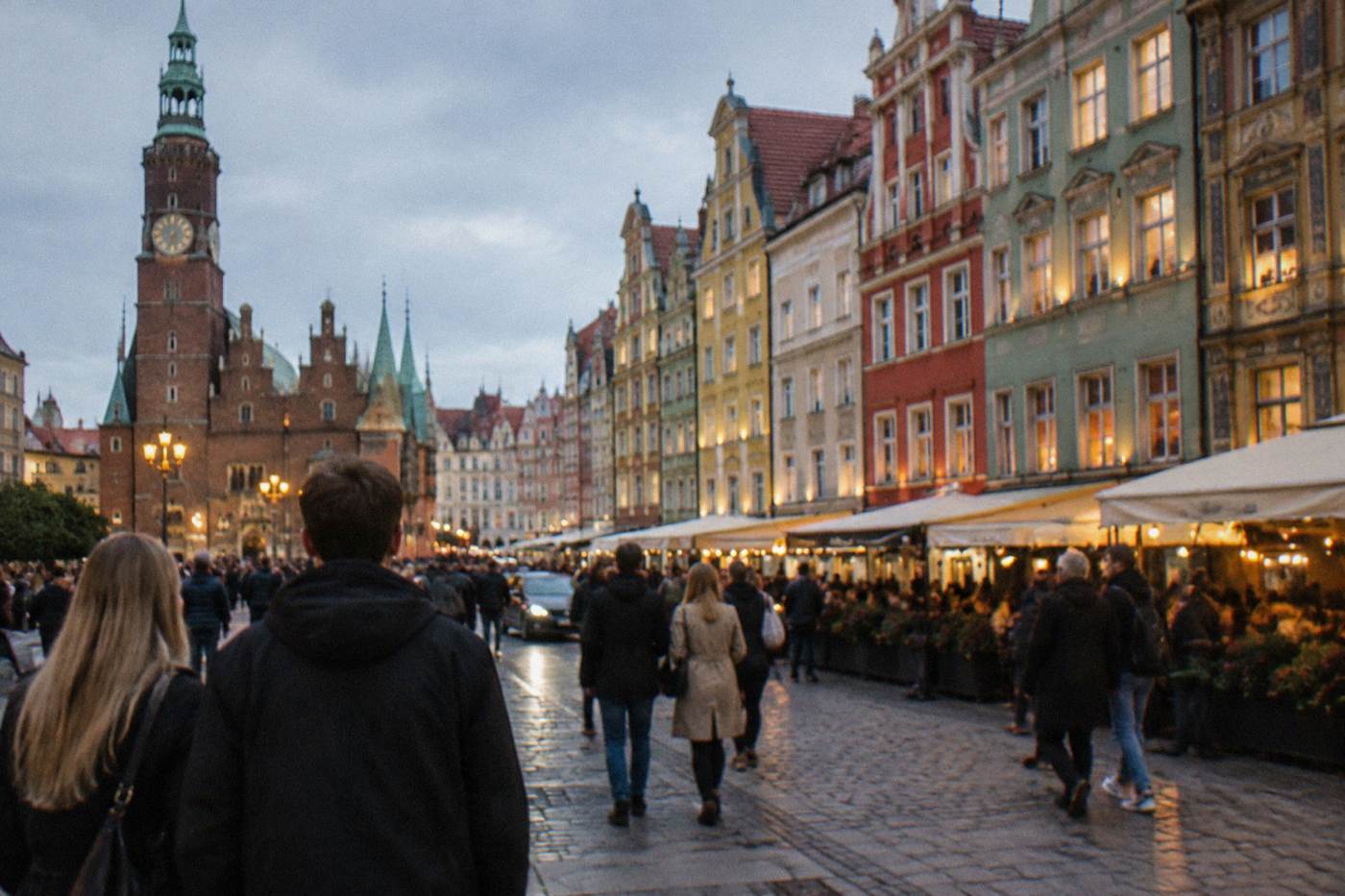 Evening crowds under lit windows on the edge of Wroclaw's Market Square