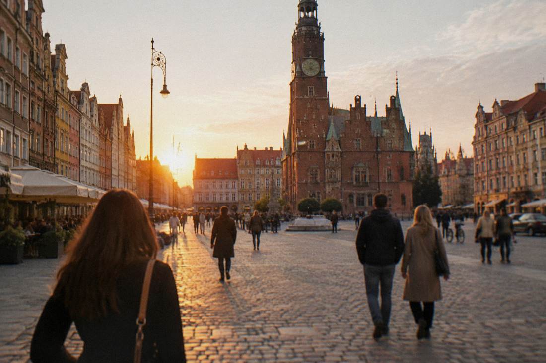 Visitors strolling across the Market Square in Wroclaw in late afternoon light