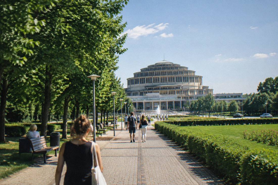 A green park avenue leading toward the domed hall on the horizon