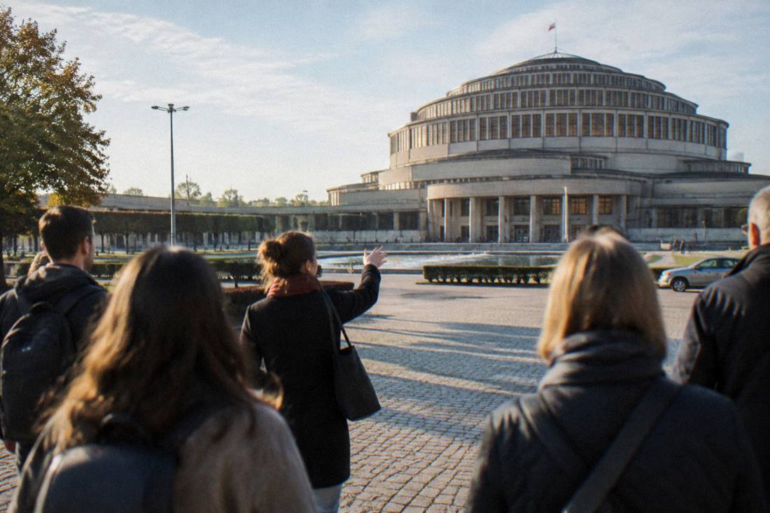 A guide leading a small group of visitors across an old city square