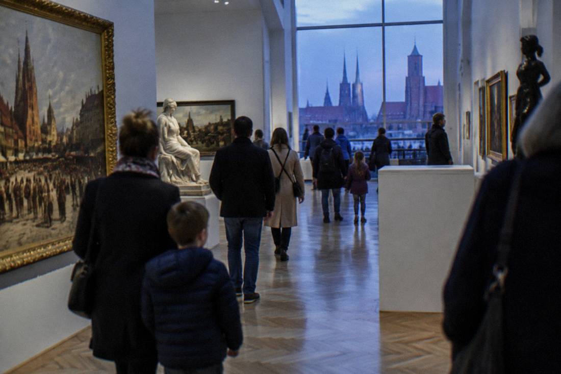 Families and visitors walking through a bright gallery of the National Museum in Wroclaw