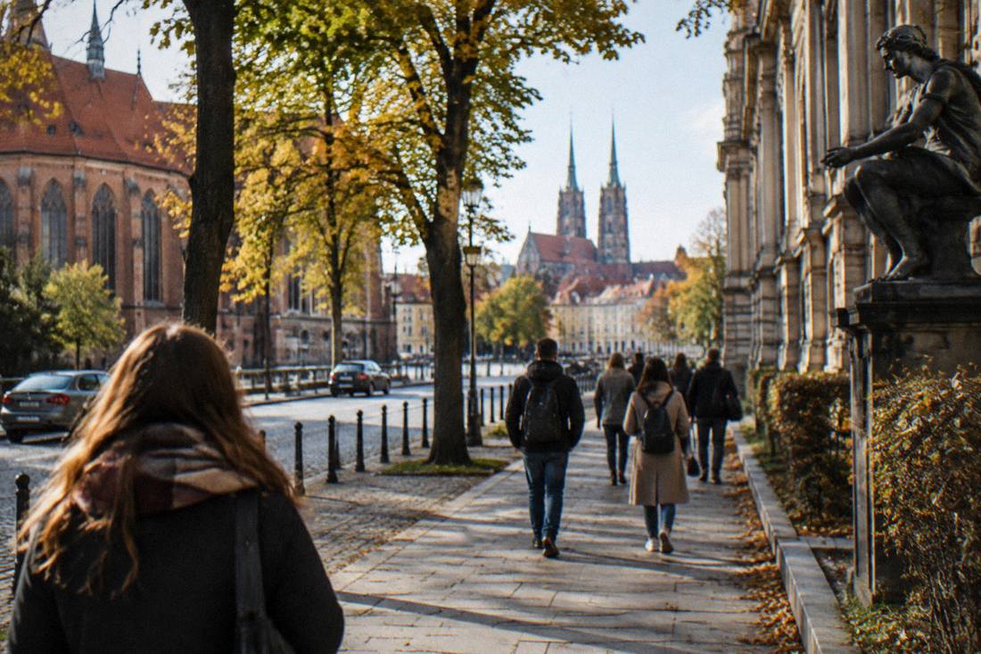 Visitors strolling a tree-lined street in central Wroclaw between museum stops