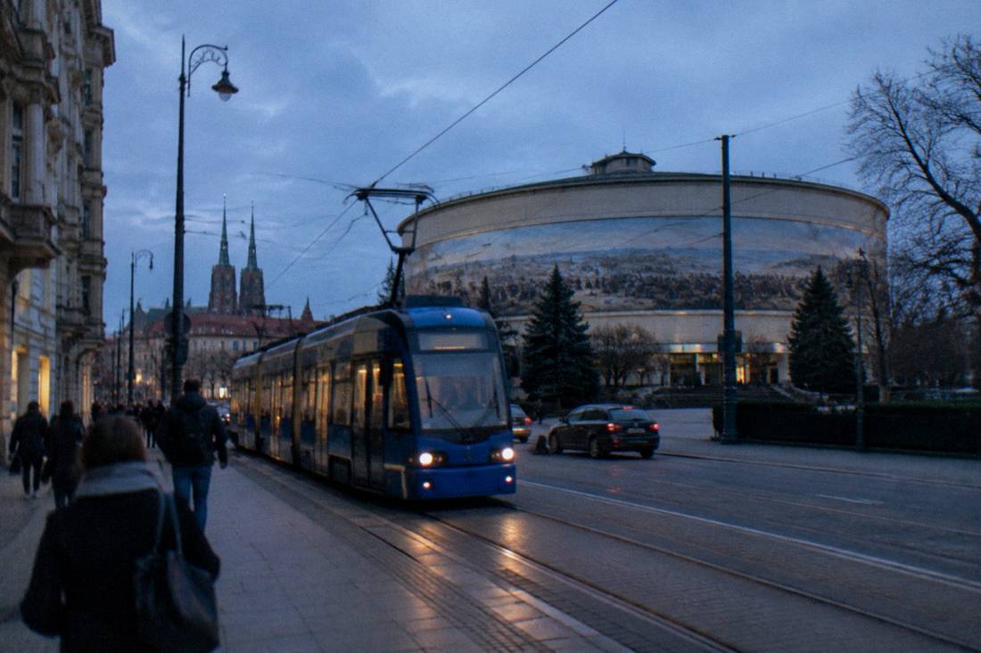 A tram moving along a street with historic buildings in central Wroclaw