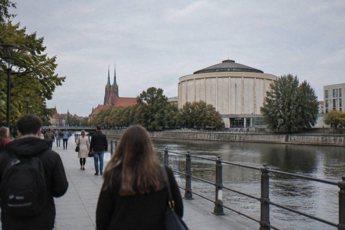 Visitors walking along a riverside promenade near the museum quarter