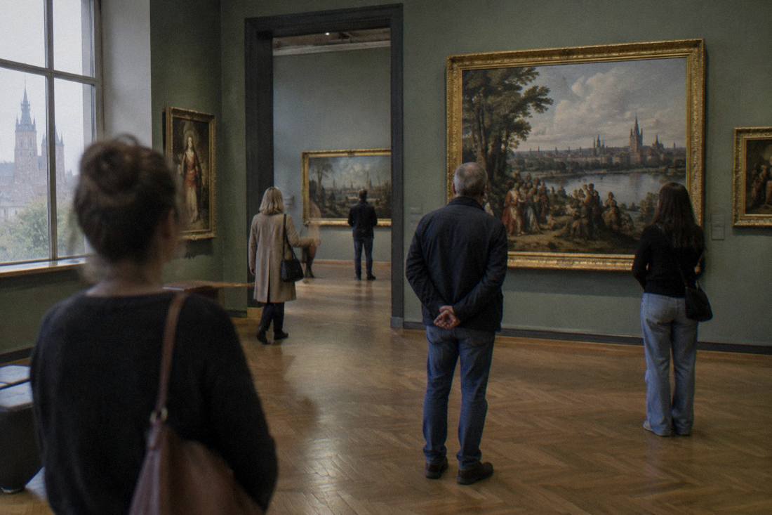 A gallery of paintings inside a national museum building with visitors looking at the art