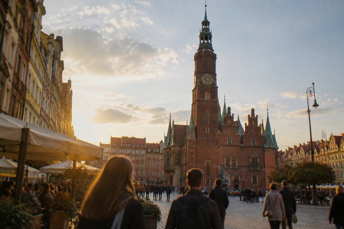 The ornate gothic tower of a historic town hall rising above a public square
