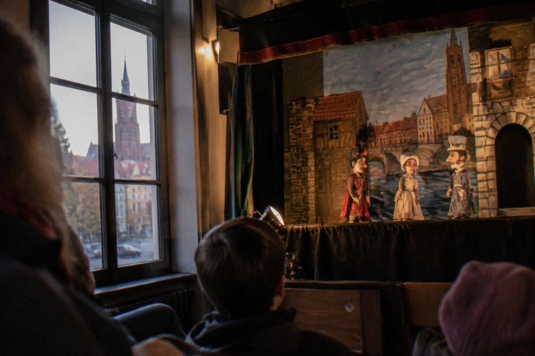 Colorful puppet figures displayed on a small stage inside a theatre in Wroclaw