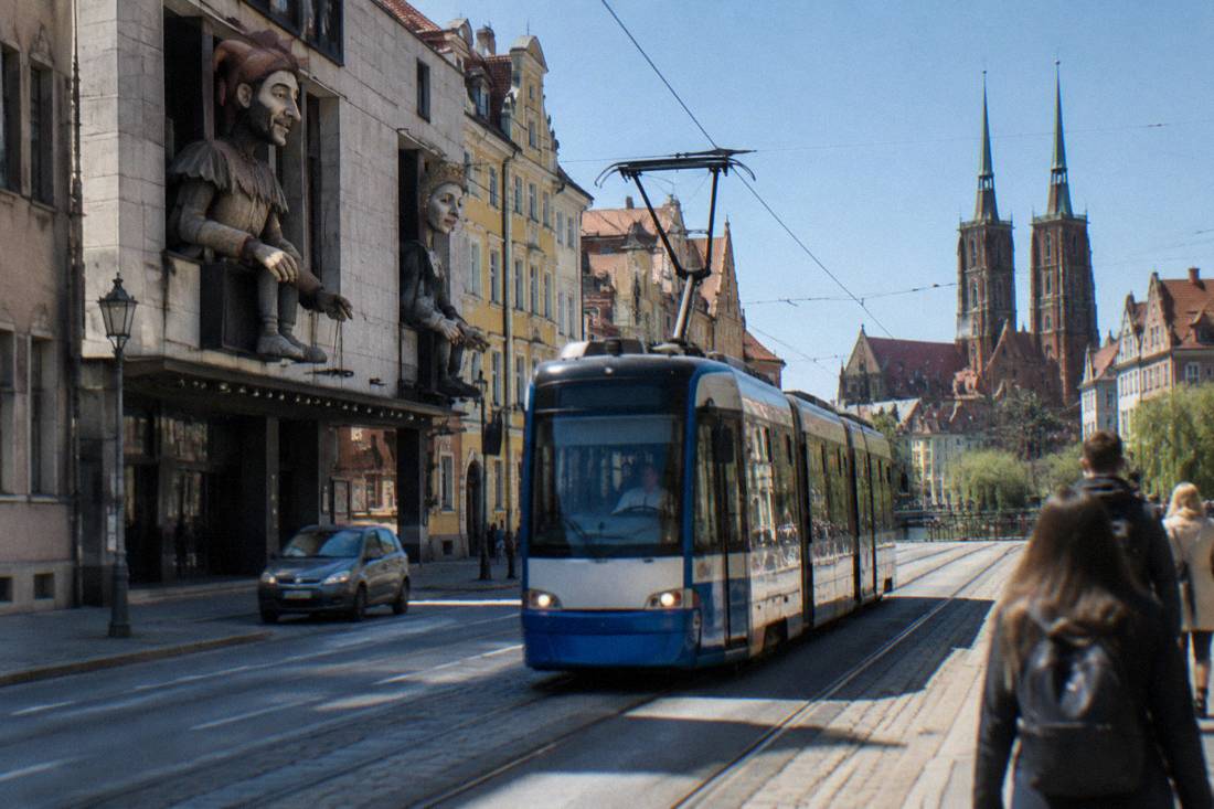 A tram moving down a street in central Wroclaw near the historic district