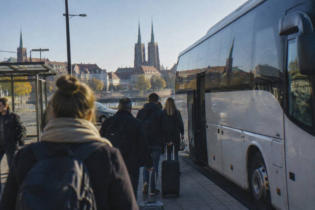 A long-distance coach parked at a departure point in Wroclaw in early morning light