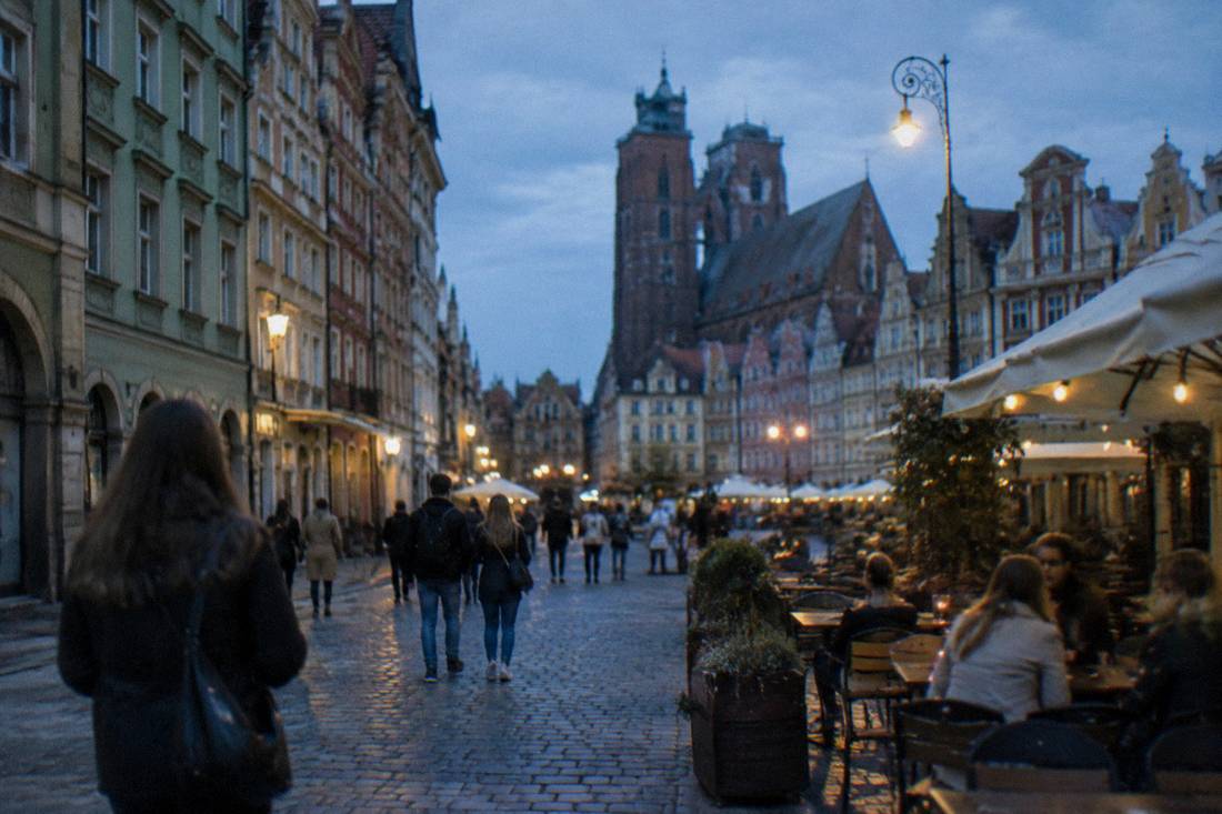 An old town street with restored facades and outdoor cafe tables