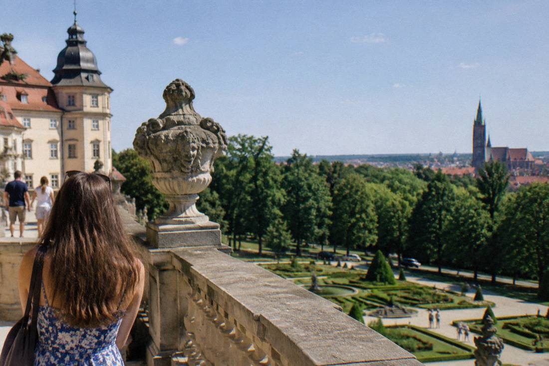 A grand castle terrace overlooking gardens and woodland in Poland