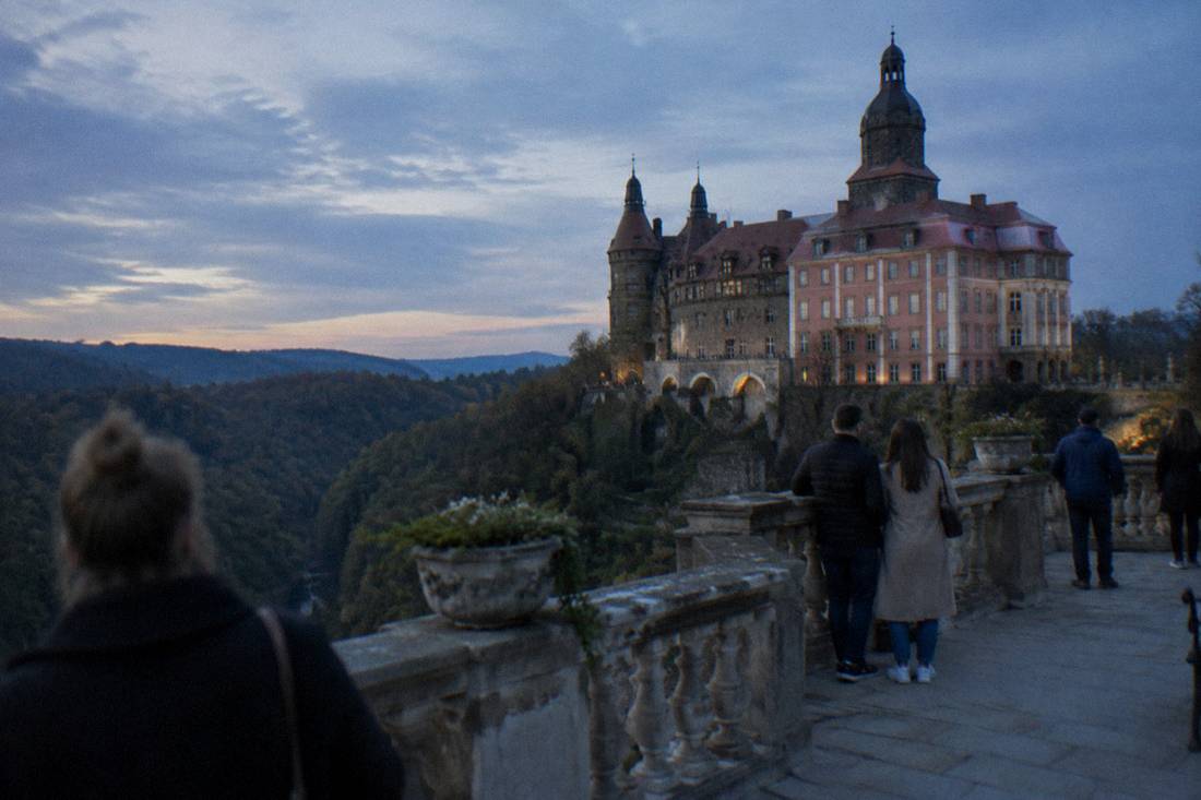 Baroque hilltop castle with a large terrace view above forested hills