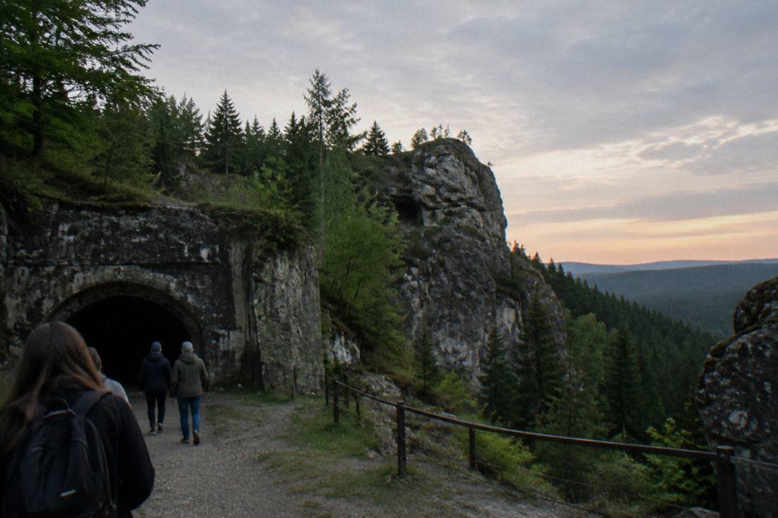 Rock formations on a forested mountain ridge under an evening sky