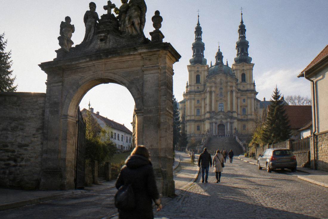 Stone gate and village street in Wambierzyce leading toward the basilica entrance