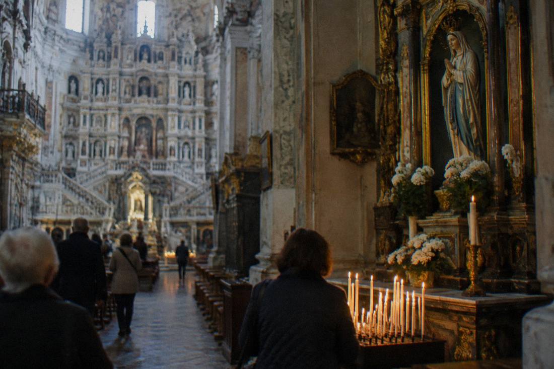 Candle-lit side altar with a statue of the Virgin Mary inside the Wambierzyce basilica