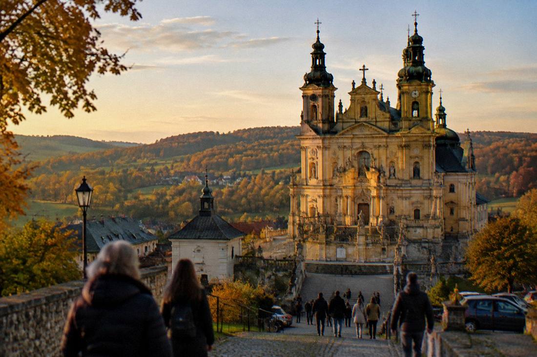 Golden evening light on the basilica facade and the hills of Wambierzyce