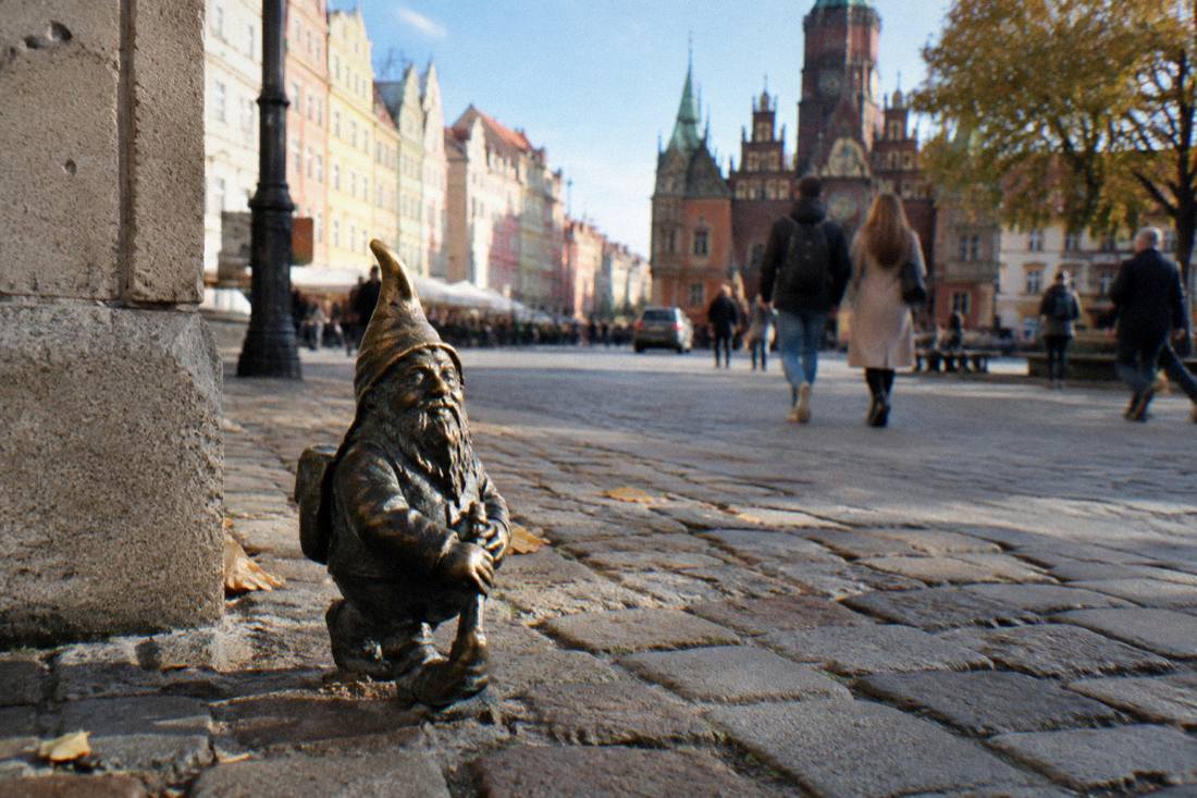A small bronze dwarf statue on a Wroclaw sidewalk near the Market Square