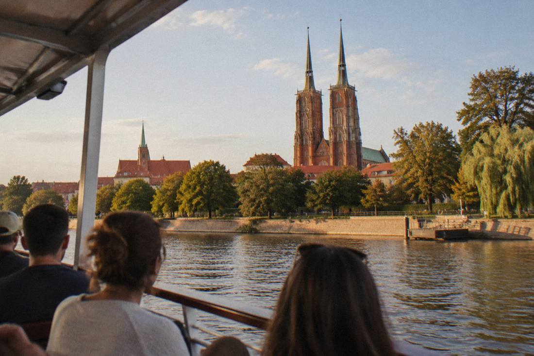 View from a river boat of Wroclaw's cathedral towers above the Odra embankment trees