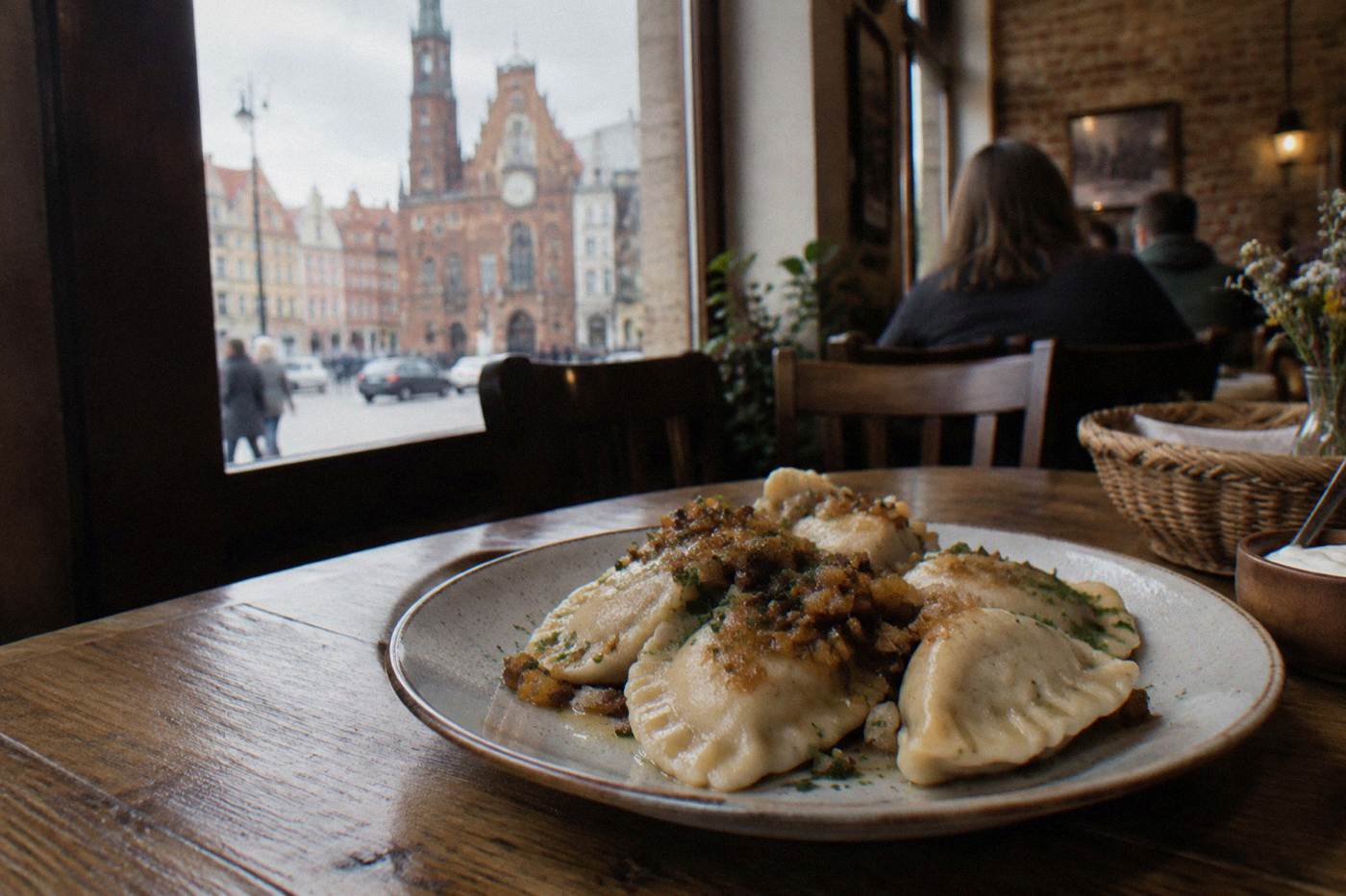 A plate of pierogi dumplings on a wooden table in a cozy Polish restaurant