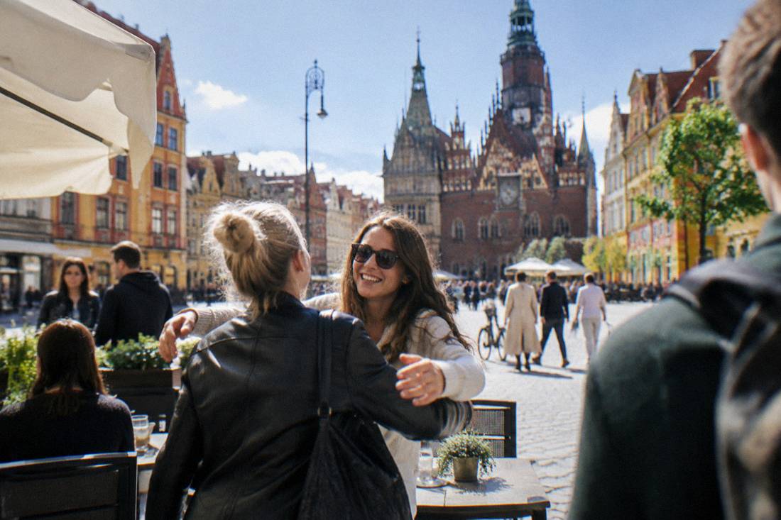 People greeting each other at a cafe terrace in Wroclaw's old town