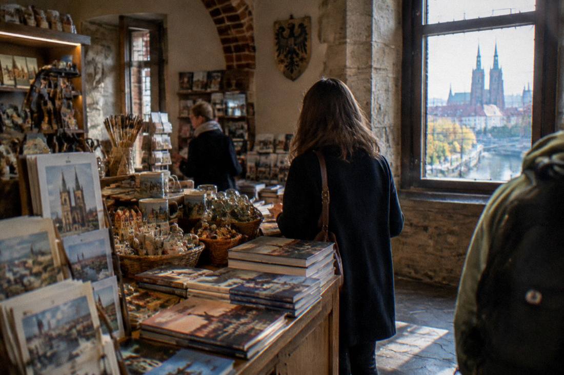 A gift shop counter with books and souvenirs inside a historic castle site near Wroclaw