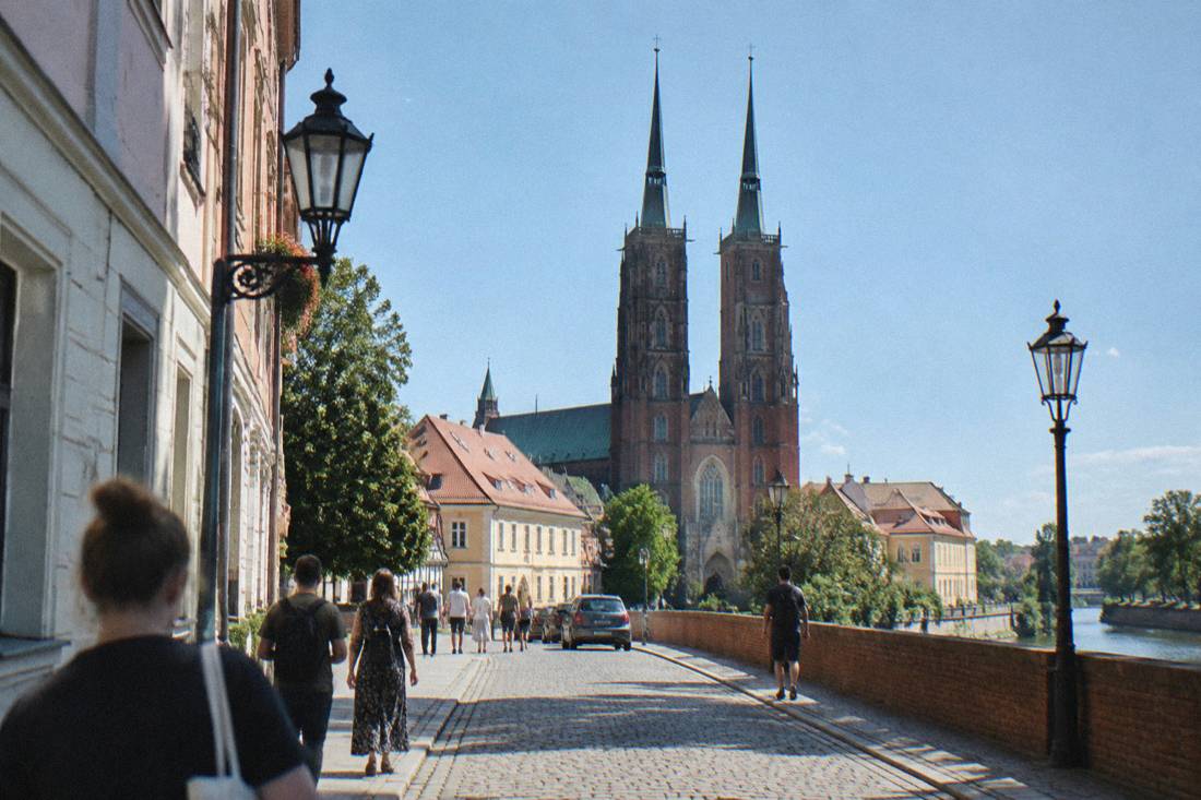 Cobblestone street on Cathedral Island in Wroclaw with church towers and old lamp posts
