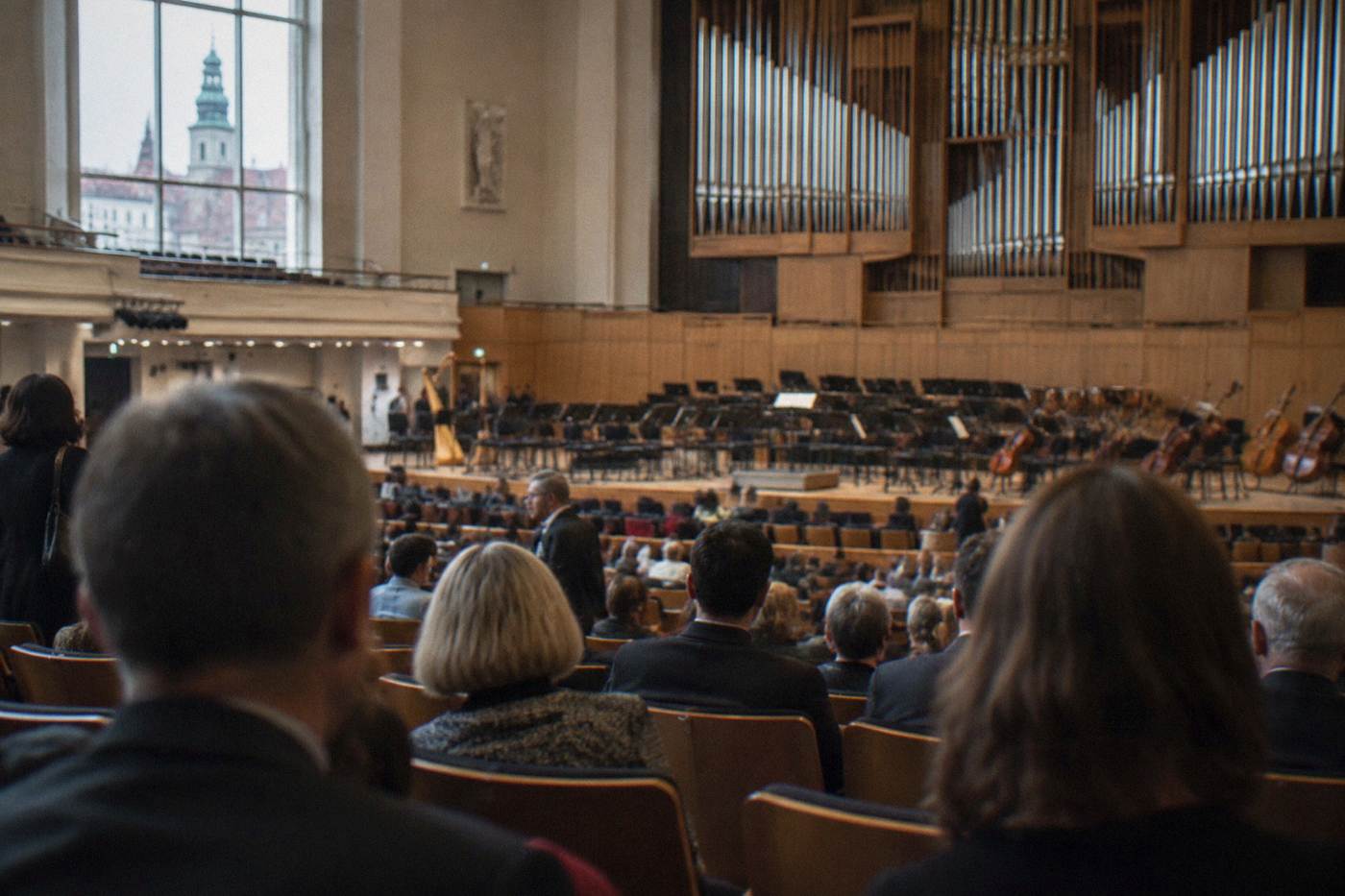 A concert hall audience waiting for an orchestral performance to begin in Wroclaw
