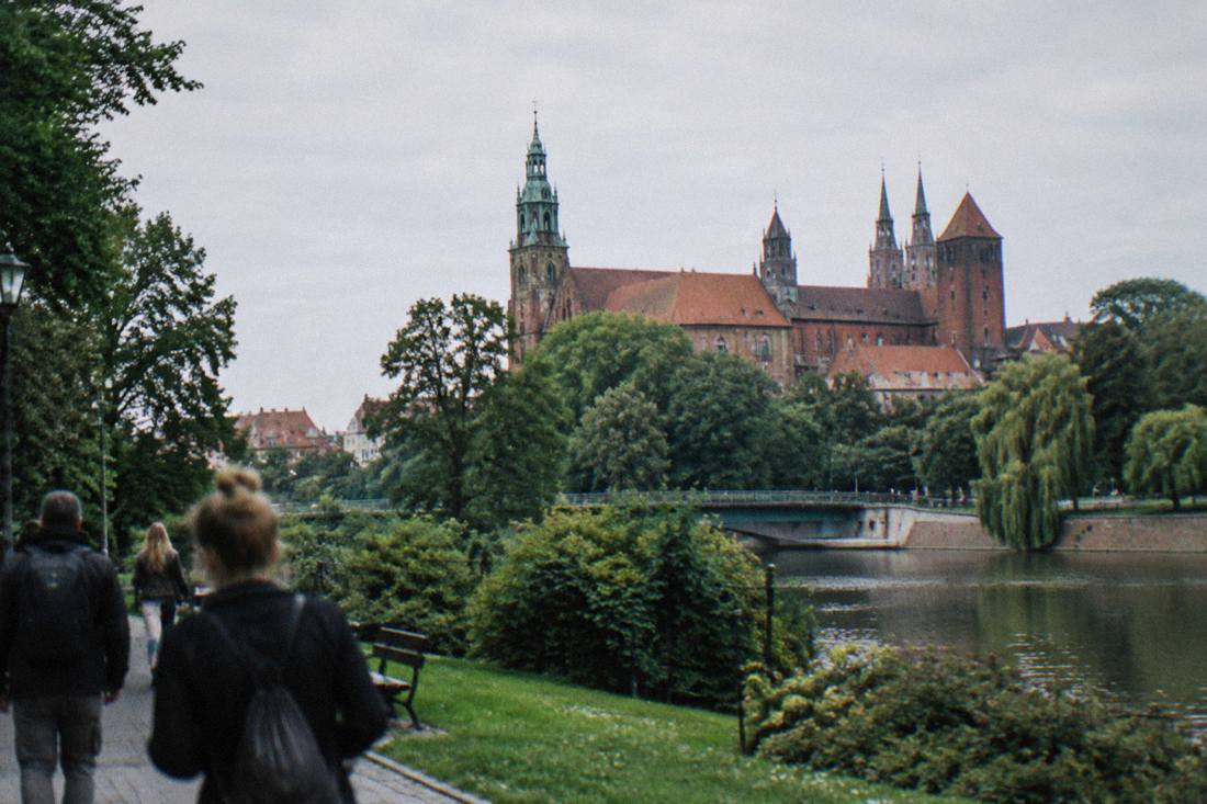 A large castle with tall towers rising above green parkland