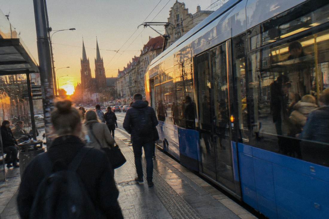 Modern low-floor tram stopped at a busy street stop in central Wroclaw