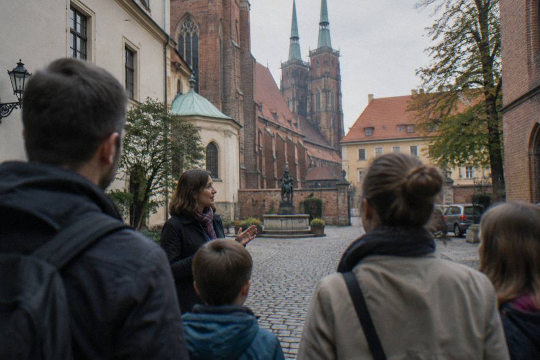A small family group with a guide listening to a story in a Wroclaw old town courtyard