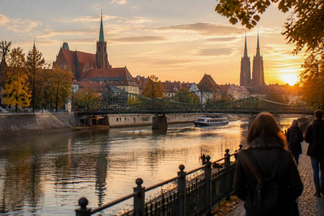 A riverside city view at golden hour with bridges spanning the Odra and church towers behind