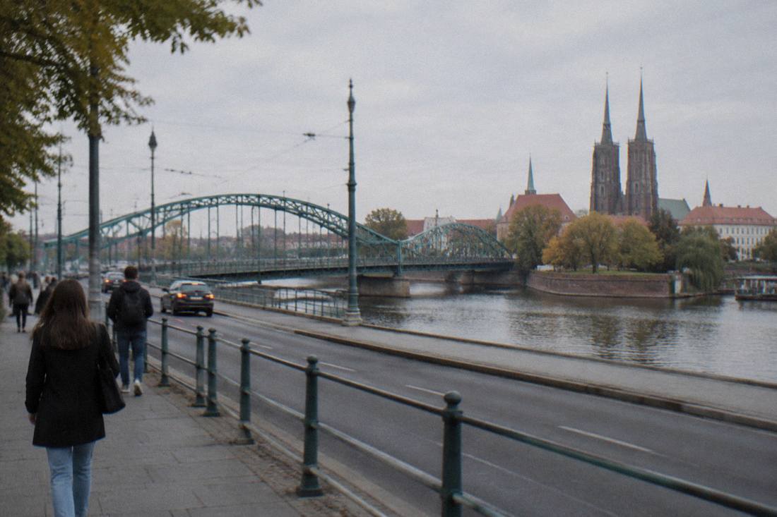 A quiet Wroclaw street with the Odra river and cathedral spires in the background