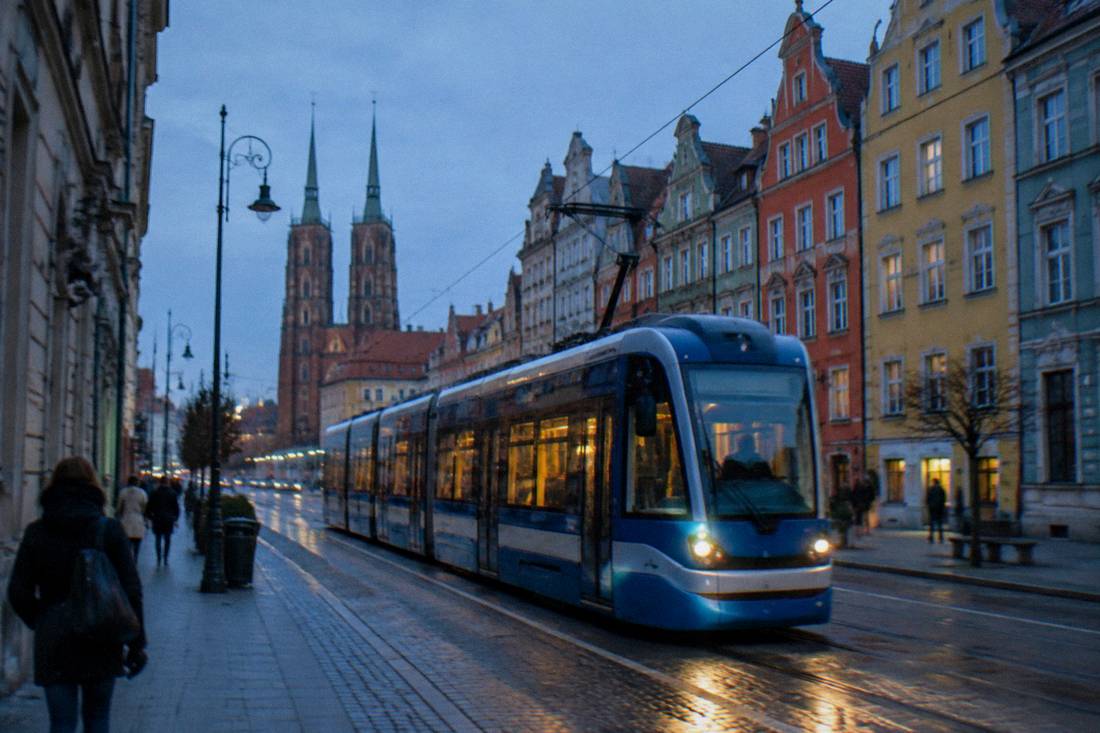 A modern Wroclaw tram passing colorful townhouses on a street in the city center