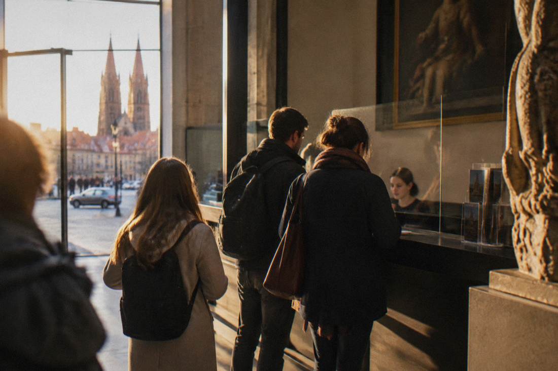 Visitors buying tickets at a museum counter in Wroclaw