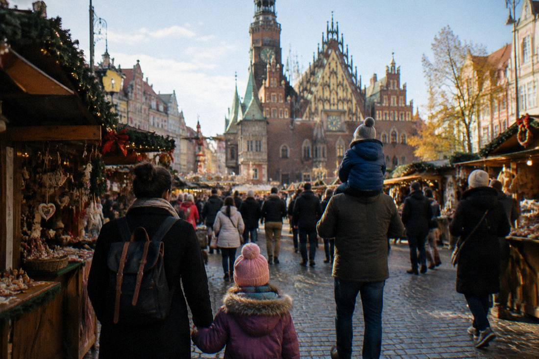 Families with children walking among decorated market stalls in Wroclaw