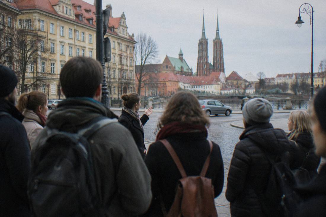 A guided walking group gathered on a Wroclaw street corner