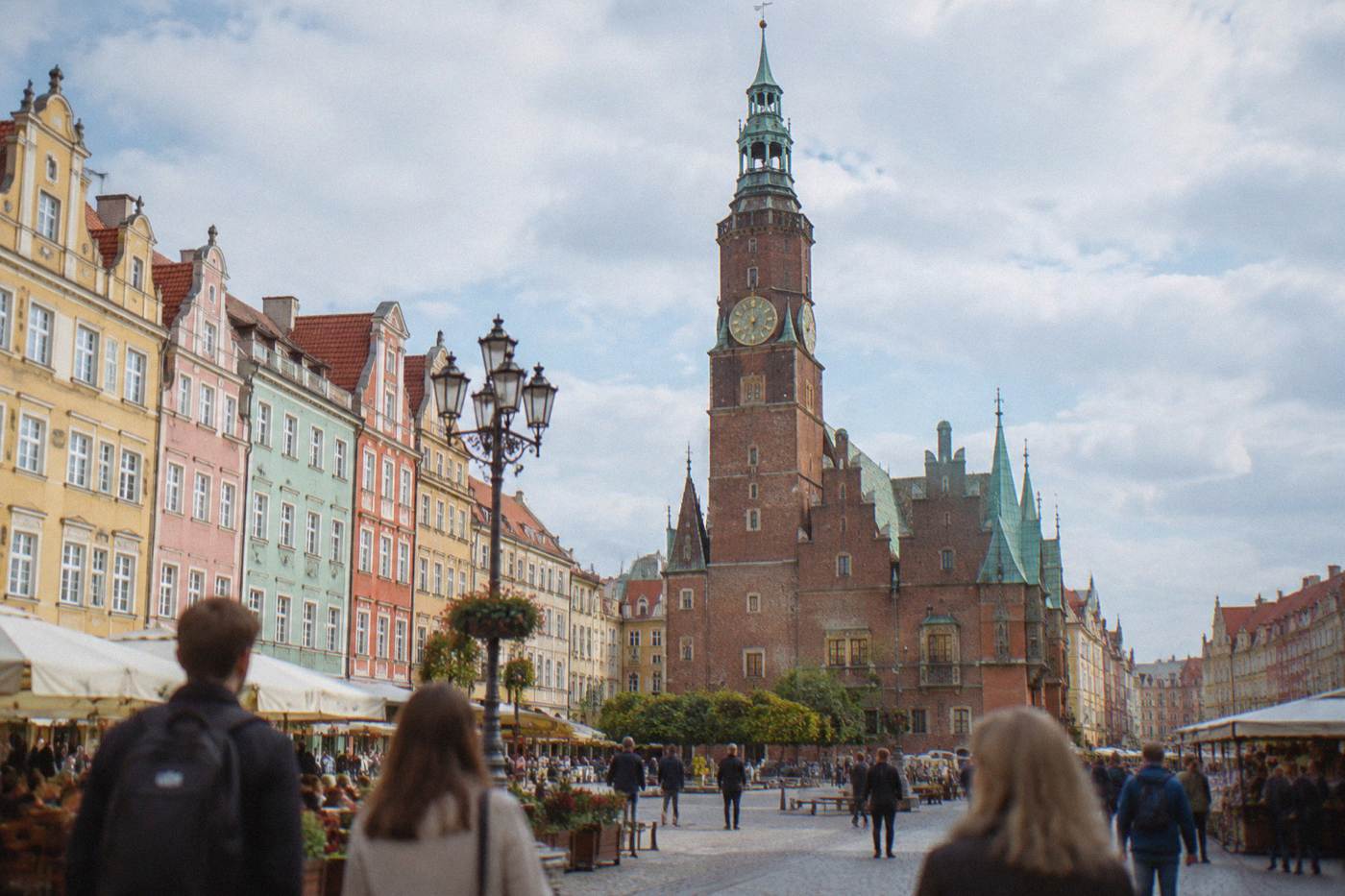 The old town hall tower and colorful townhouses of Wroclaw's market square seen from below