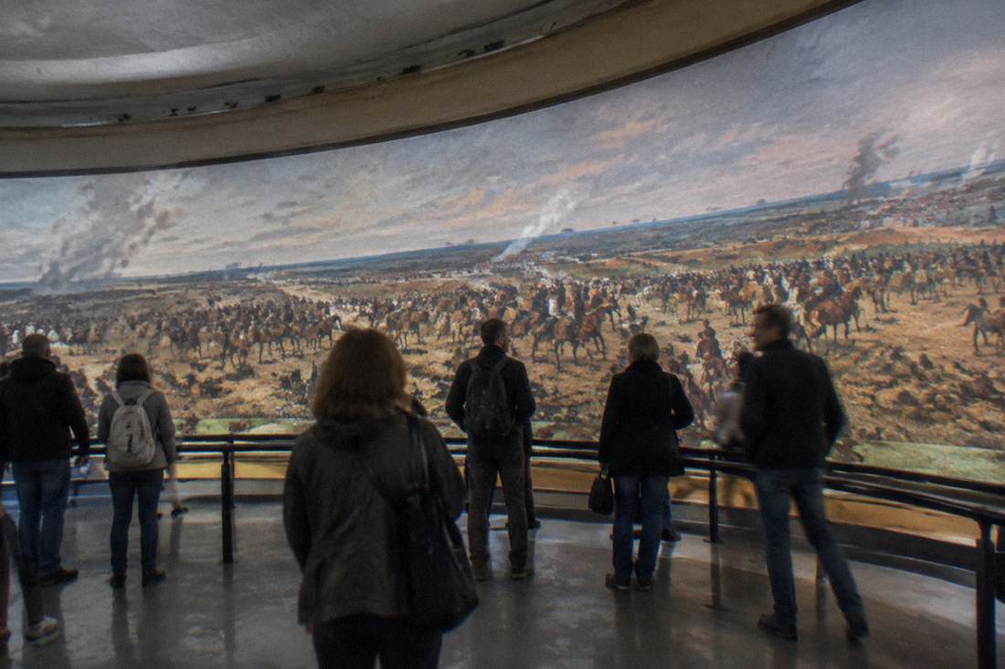 Visitors viewing a large panoramic painting displayed in a circular gallery inside the Panorama Raclawicka building
