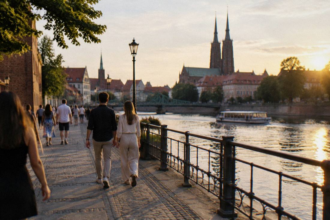 A riverside boulevard in Wroclaw in warm evening light with people strolling without bags