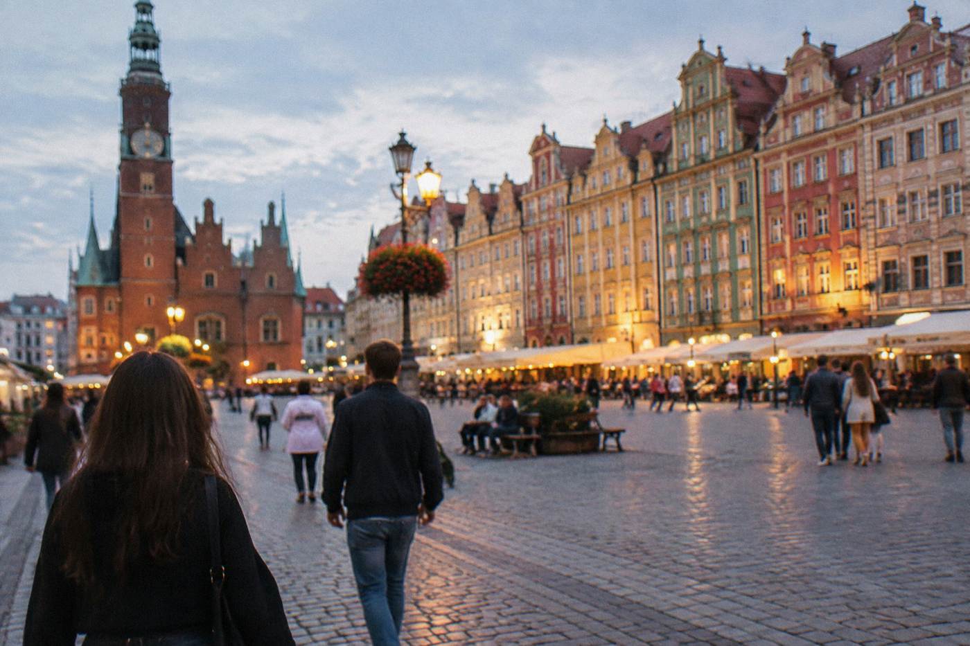 Illuminated historic townhouses around a large market square on a warm evening