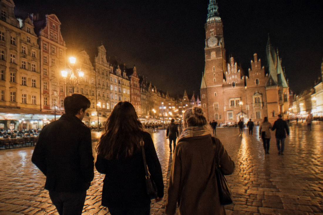 Friends walking together across an illuminated old town square late at night