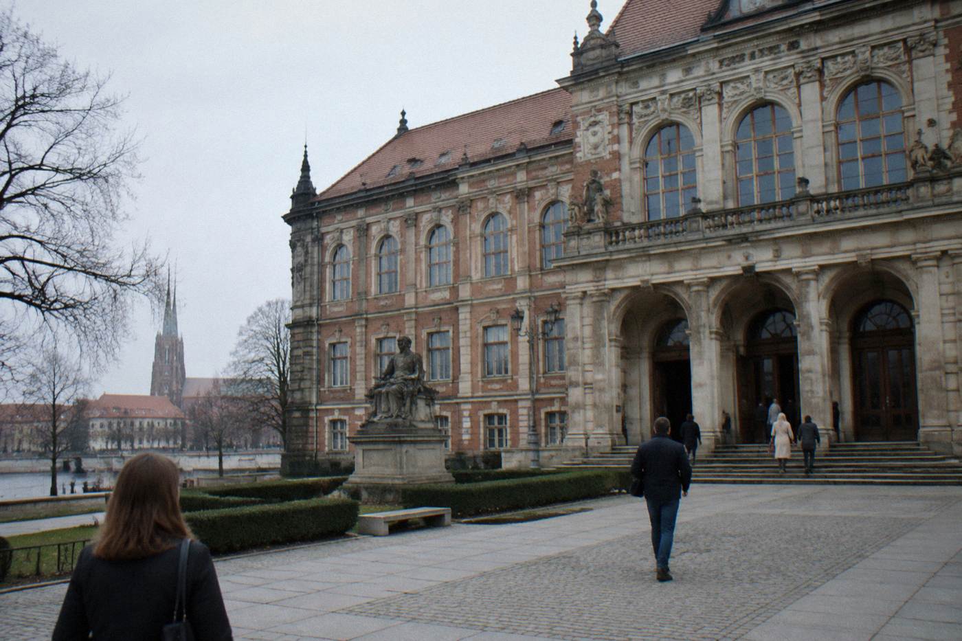 The front of the National Museum in Wroclaw on a quiet morning with a few visitors at the entrance