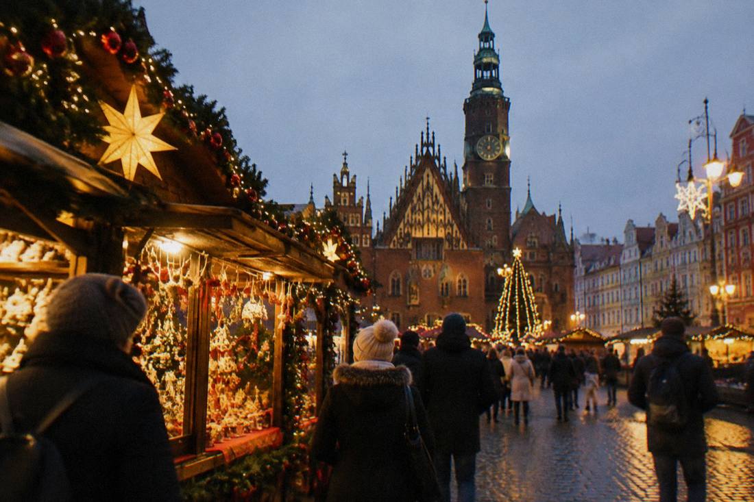 A Christmas market stall with lights and decorations on the Wroclaw Market Square in the evening