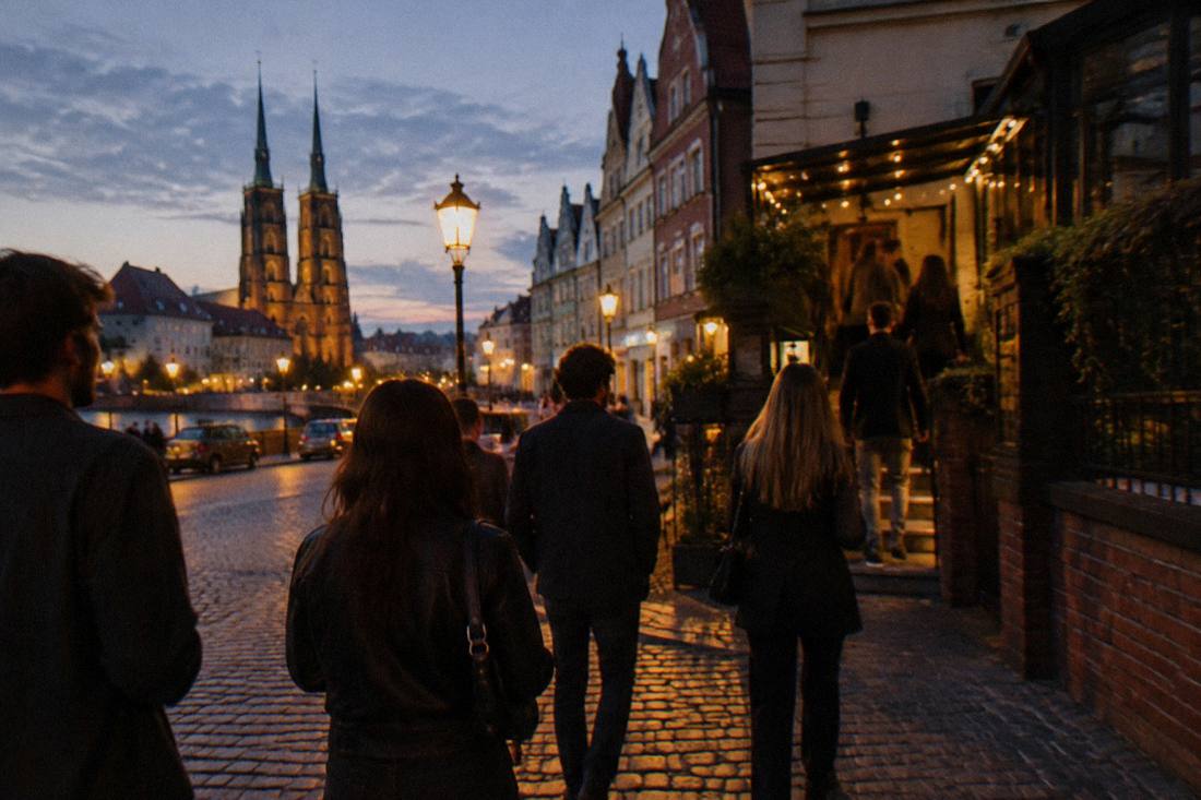A group of friends walking through the lamp-lit streets of Wroclaw Old Town at night toward a rooftop bar entrance.