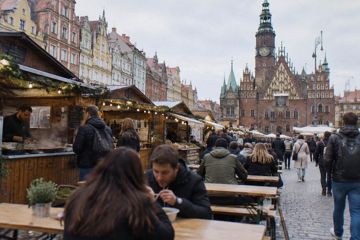 Food market stalls in the center of Wroclaw with people eating at outdoor tables