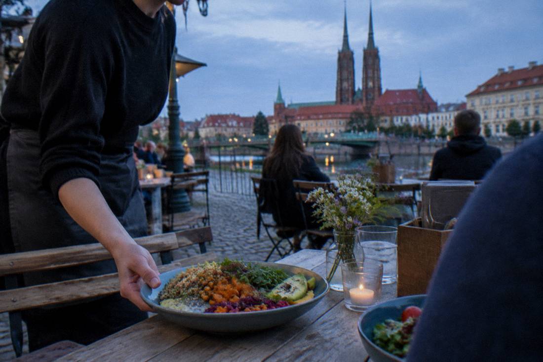 A colorful vegetarian meal being served at an outdoor table in Wroclaw