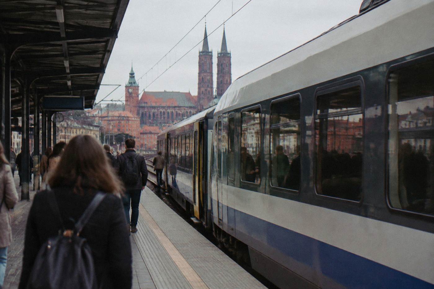 A passenger train waiting at a platform in a Polish railway station