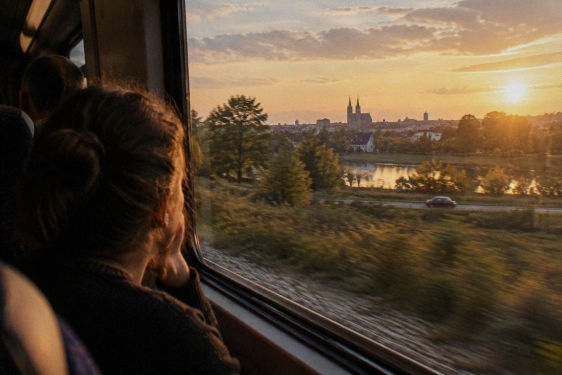 A passenger looking out the window of a moving train at the Polish countryside